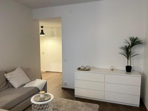 a living room with a couch and a dresser at Viihtyisä kaksio Annalassa, Free parking & Sauna in Tampere