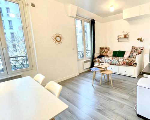 un salon avec un canapé et une table dans l'établissement Charming Bright Sunny Studio near Canal St Martin, à Paris