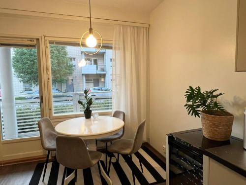 a dining room with a table and chairs and a window at Viihtyisä kaksio Annalassa, Free parking & Sauna in Tampere