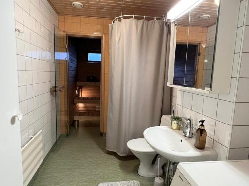 a bathroom with a sink and a toilet and a shower at Viihtyisä kaksio Annalassa, Free parking & Sauna in Tampere