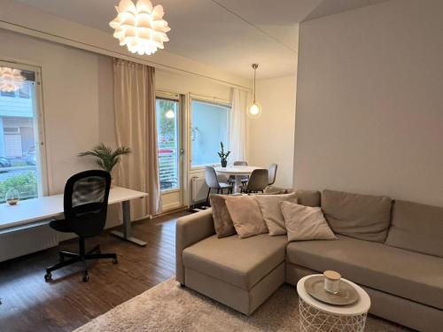 a living room with a couch and a table at Viihtyisä kaksio Annalassa, Free parking & Sauna in Tampere