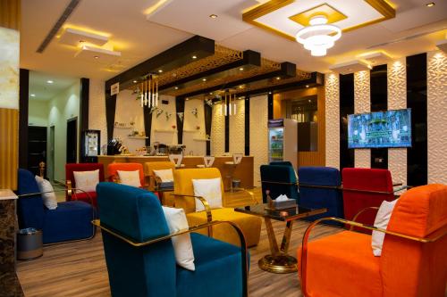 HOTEL ALFAW PLAZA في شرورة: مطعم يحتوي على كراسي ملونة وطاولة