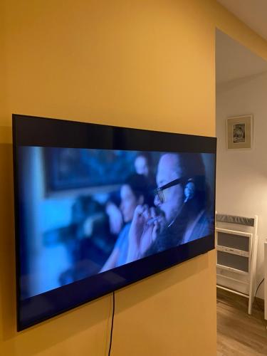 einen Flachbild-TV, der an einer Wand hängt in der Unterkunft Modern and well done flat Geneva - self check-in in Saint-Genis-Pouilly
