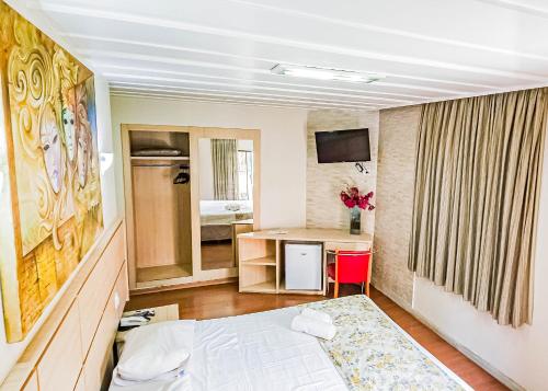 um quarto com uma cama, uma secretária e uma mesa em Hotel Euro Suite São Paulo by Nacional Inn - A 600 METROS DA RUA 25 DE MARÇO em São Paulo
