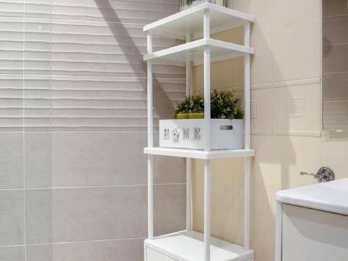 a white shelf in a bathroom with two plants on it at Bilbao San Mamés by Aston Rentals in Bilbao