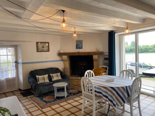 a living room with a table and a couch at Maison du pêcheur , située sur les bords de la Loire dans un lieu calme et paisible. in Rochefort-sur-Loire