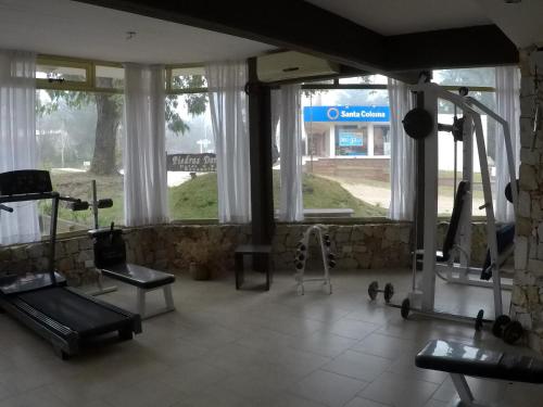 een kamer met ramen en een fitnessruimte met een loopband bij Piedras Doradas Hotel y Spa in Valeria del Mar