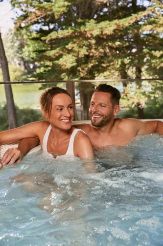 a man and a woman in a swimming pool at Résidence Valdys Thalasso & Spa - les Pins in Saint-Jean-de-Monts