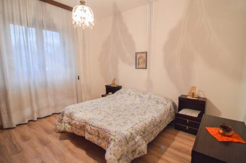 um quarto com uma cama e um lustre em CASA VACANZE NONNO ASTERIO em Monfalcone