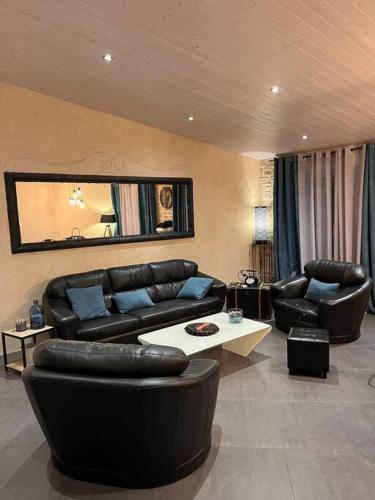 - un salon avec un mobilier en cuir noir et un miroir dans l'établissement Villa classée 4* Piscine/Spa/Sauna/Salle de sport, à Longeville-sur-Mer
