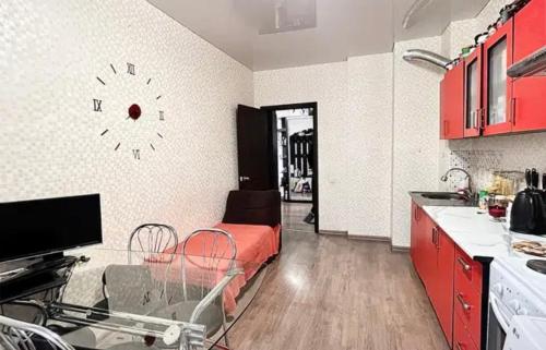 uma cozinha com armários vermelhos e um relógio na parede em VIP apart 572 em Tbilisi