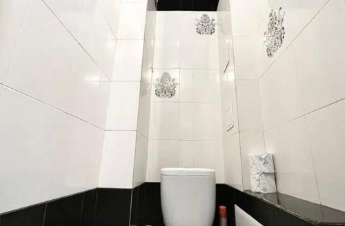 uma casa de banho com azulejos brancos e um WC. em VIP apart 572 em Tbilisi