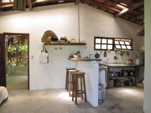 cocina con encimera y taburetes en una habitación en The Bright Houses en Moreré