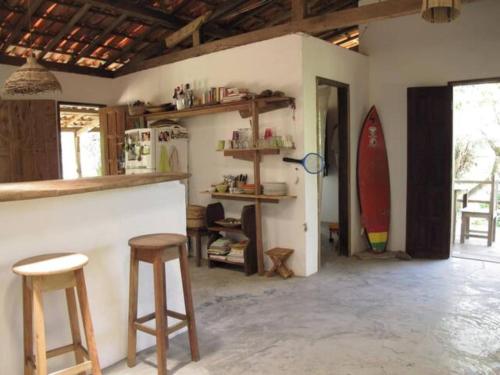 cocina con 2 taburetes y barra con tabla de surf en The Bright Houses en Moreré