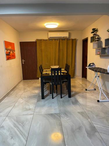 a dining room with a black table and chairs at Amazing Grace Villa in Accra
