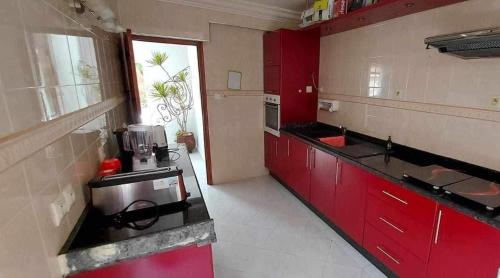 cocina con armarios rojos y encimera en salam, en Agadir