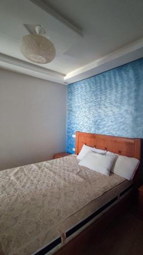 1 dormitorio con 1 cama con pared azul en salam, en Agadir