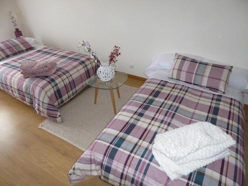a bedroom with two beds and a table with a vase at El Enebro in Lerma