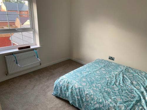 a bedroom with a bed next to a window at 3 Lace Avenue LE11 2FE in Loughborough