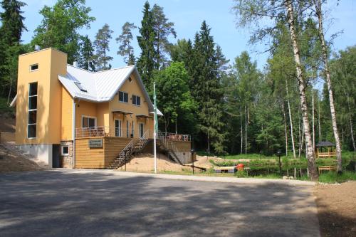 a yellow house with a metal roof at Tehvandi Puhkemaja in Otepää