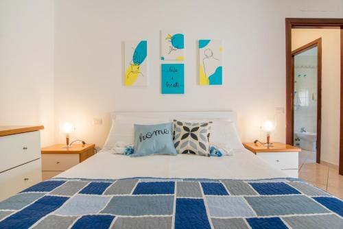 um quarto com uma cama e duas mesas de cabeceira e dois candeeiros em [Oristano centro] Parcheggio privato, Wifi+Netflix em Oristano