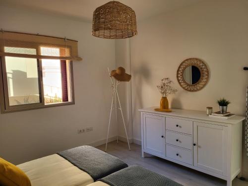 a bedroom with a bed and a dresser and a mirror at La Casita de Mía in La Restinga