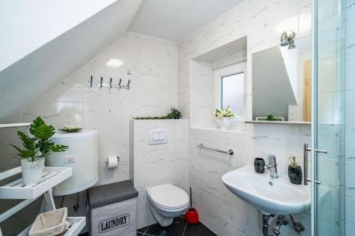 a white bathroom with a toilet and a sink at Plaza Royal in the centre in Dubrovnik