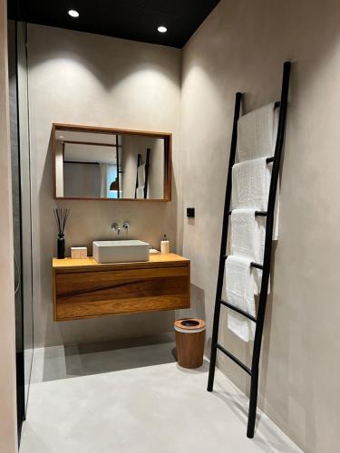 a bathroom with a sink and a shelf with towels at Hostal del vino LA COSTERA in Altea