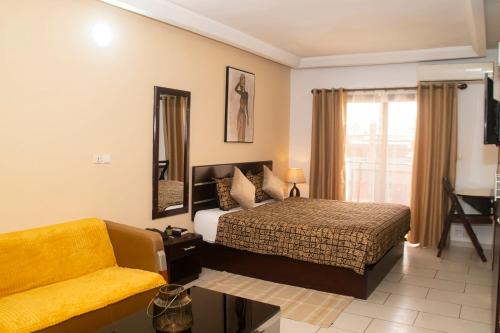 a hotel room with a bed and a couch at Enka Flat Hotel in Abidjan