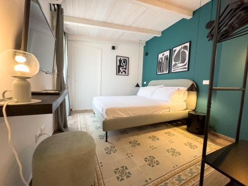 1 dormitorio con 1 cama y 1 silla en Piccolo Torino Rooms, en Canicattì