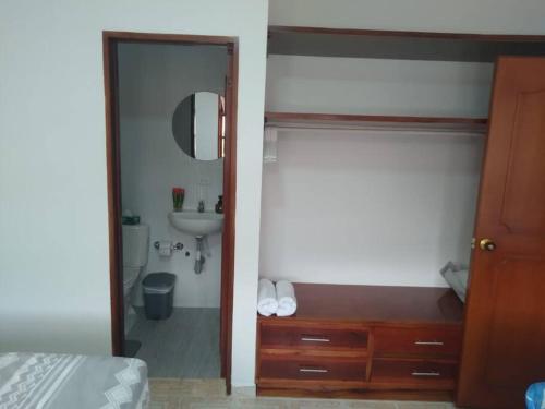 ein Bad mit einem Waschbecken und einem Spiegel sowie ein Schlafzimmer in der Unterkunft Casa bonita en San Gil in San Gil