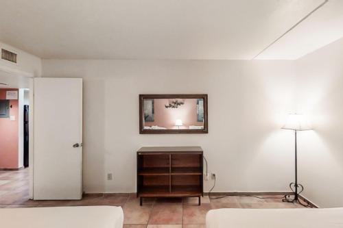 um quarto branco com uma cómoda e um espelho na parede em Gulfview I #207 em South Padre Island