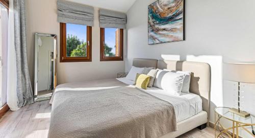 Schlafzimmer mit einem Bett mit weißer Bettwäsche und Fenstern in der Unterkunft Villa HG21 Olympus in Kouklia
