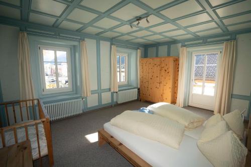 a bedroom with a bed and two windows at Villa Hartenfels 2 in Scuol