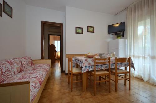een woonkamer met een tafel en een bank bij Residenza Orsa Maggiore in Lignano Sabbiadoro