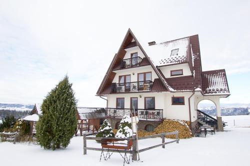 a house in the snow with a christmas tree at DOM BUDZOWA 2B in Murzasichle