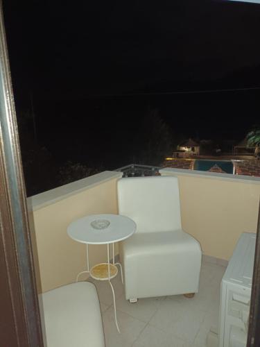a table and two chairs on a balcony at night at Hotel Caserta Antica in Caserta