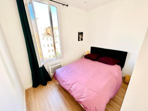 - une chambre avec un lit rose et une fenêtre dans l'établissement Cosy flat in the heart of Marseille, à Marseille