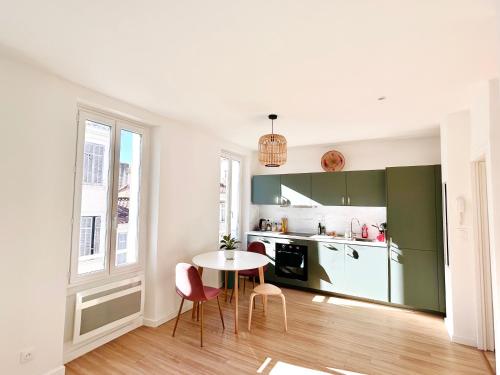 une cuisine avec une table et des chaises dans une pièce dans l'établissement Cosy flat in the heart of Marseille, à Marseille