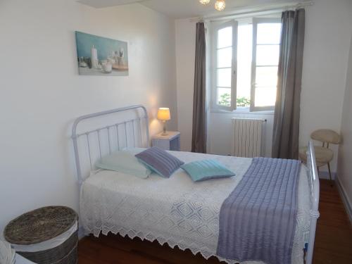 1 dormitorio con 1 cama con 2 almohadas y ventana en Le Clos Fleuri, en Caumont