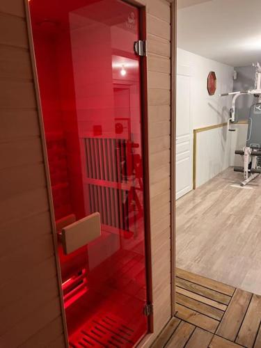 a red glass door of a bathroom with a hallway at L’appart classé 4* in Longeville-sur-Mer