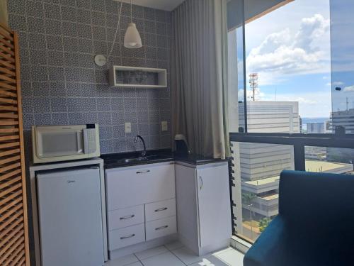 a kitchen with a sink and a microwave at GARVEY PARK HOTEL in Brasília