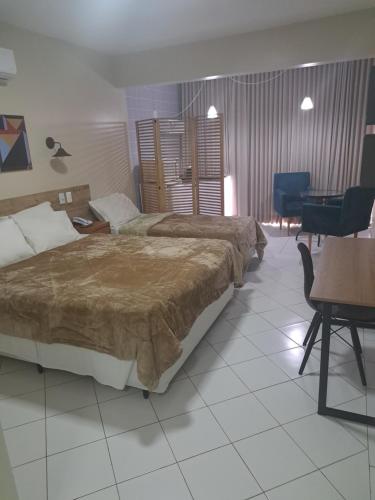 GARVEY PARK HOTEL في برازيليا: غرفة فندقية بسريرين وطاولة