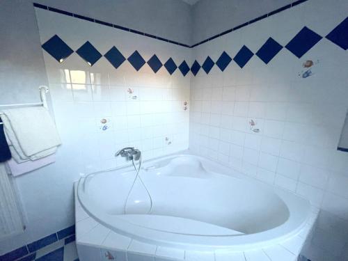 a white tub in a bathroom with blue and white tiles at Maison de 4 chambres avec jardin clos et wifi a Arcy Sainte Restitue in Arcy-Sainte-Restitue