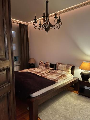 a bedroom with a bed and a chandelier at Uroczy apartament 97m2 w samym centrum Wrocławia in Wrocław