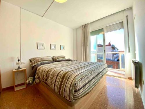 a bedroom with a bed and a large window at Big Family Terrassa Parking and noise free in Terrassa