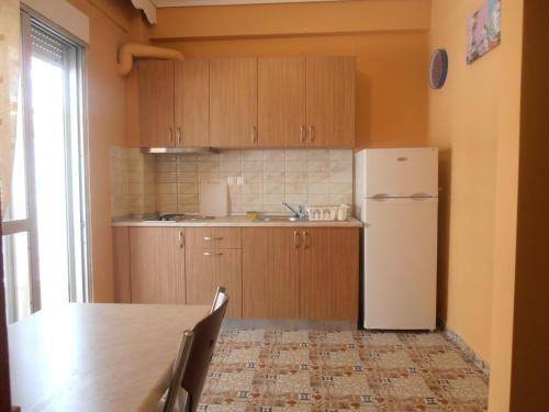 a kitchen with a table and a refrigerator at Apartments Palladium in Olympiaki Akti