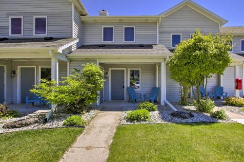 a house with blue chairs in the front yard at Door County Getaway - Walk to State Park! in Fish Creek