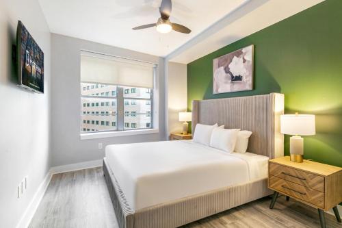 a bedroom with a white bed and a green wall at 4BD Oasis - Steps to French Quarter with Free Parking in New Orleans
