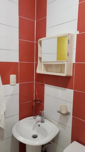 ein Bad mit einem Waschbecken und einem Spiegel in der Unterkunft Petite Lounge in Los Paredones